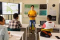 Teaching math, teacher using tablet in classroom with students at high school Royalty Free Stock Photo
