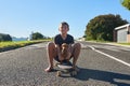 Teaching my dog has to skate. Full length portrait of a young boy and his dog sitting on a longboard. Royalty Free Stock Photo