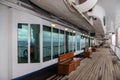 Teak bench and teak lined Promenade Deck of modern cruise ship on a grey stormy day Royalty Free Stock Photo