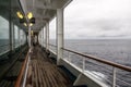 Teak lined Promenade Deck of modern cruise ship on a grey stormy Royalty Free Stock Photo