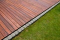 Teak wood deck detail next green grass, natural exotic hardwood lumber outdoor flooring Royalty Free Stock Photo