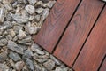 Teak wood decking next .stone bark ground cover, teakwood texture and grains contrasting with decorative stones