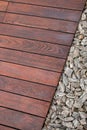 Teak wood decking next .stone bark ground cover, teakwood texture and grains contrasting with decorative stones