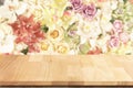 Teak wood table top with colorful roses flowers background.