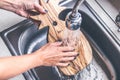 Teak wooden cutting board washing. Woman hands washing teak cutting board. Royalty Free Stock Photo