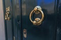 Teal color doors and two round brass door knocker