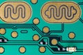 A teal colored circuit with many gold colored electrical contacts.