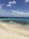 Teal colored oceans next to sandy beach