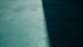 Teal concrete surface with sharp diagonal shadow and subtle cracks Royalty Free Stock Photo