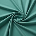 A teal fabric arranged in a spiral pattern creates a swirling effect. The material has a Royalty Free Stock Photo