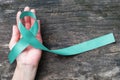 Teal ribbon awareness on woman\'s hand for Ovarian Cancer, Polycystic Ovary Syndrome (PCOS) disease