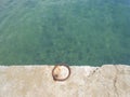 Teal waters and an iron ring in a dock