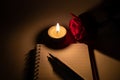 Tealight candle, pen, note book and roses Royalty Free Stock Photo