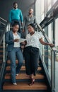 Team of African business people walking down stairs, women leading Royalty Free Stock Photo