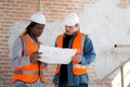 Team of architect or engineer wearing hardhat looking blueprint for inspection and planning construction.