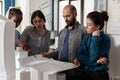 Team of architects analyzing blueprints for building project standing in front of table Royalty Free Stock Photo