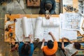 Team of Architects Collaboratively Designing Innovative Building Blueprints with Precision and Creativity, Utilizing Detailed
