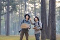 Team of the Asian naturalist looking at the map while exploring in the pine forest for surveying and discovering the rare