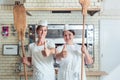 Team of baker women standing in bakery giving thumbs up