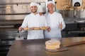 Team of bakers smiling at camera with trays of croissants Royalty Free Stock Photo