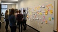 Team brainstorming ideas on a large whiteboard with sticky notes in an office Royalty Free Stock Photo