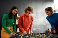 Team-building activities. Group young and excited people in casual wear playing table soccer in the modern office and Royalty Free Stock Photo