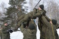 Team-building exercise: soldiers holding their fellow on hands pushing him through net