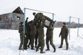 Team-building exercise: soldiers holding their fellow on hands pushing him through net