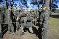 Team-building exercise: soldiers holding their fellow on hands pushing him through rope net. Novo-Petrivtsi military base, Ukraine