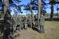 Team-building exercise: soldiers holding their fellow on hands pushing him through rope net. Novo-Petrivtsi military base, Ukraine