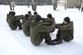 Team-building exercise: soldiers sitting on a ground and holding each other s hands