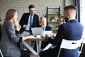 Team of business people having discussion at table in creative office Royalty Free Stock Photo