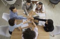 Team of business people join their hands sitting around office table in work meeting Royalty Free Stock Photo