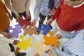 Team of business people joining colorful jigsaw puzzle pieces to show concept of teamwork Royalty Free Stock Photo
