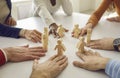 Team of business people put little human figures in circle as symbol of community and teamwork