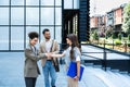 Team of business people talking in front of office building. Staff meeting quick briefing of office workers on motivational speech Royalty Free Stock Photo