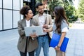 Team of business people talking in front of office building. Staff meeting quick briefing of office workers on motivational speech Royalty Free Stock Photo