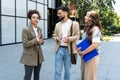 Team of business people talking in front of office building. Staff meeting quick briefing of office workers on motivational speech Royalty Free Stock Photo