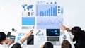 Team of business professionals analyzing data graphs and charts with digital tools while discussing strategies in a Royalty Free Stock Photo