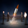 Team of businesspeople looks start a missile. Concept of company startup and new business. 3D Rendering. Royalty Free Stock Photo