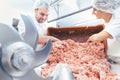 Team of butchers taking minded meat out of grinder