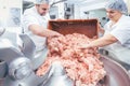 Team of butchers taking minded meat out of grinder