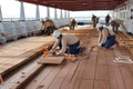 a team of carpenters and builders working on the deck of a ship