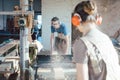 Team of carpenters planning wood using a machine