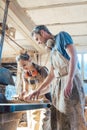 Team of carpenters working on details of a wood cut