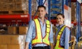 A team of Caucasian male and female engineers stood at the warehouse. Discussed loading boxes into containers at the warehouse