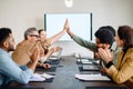 A team celebrates a shared success with high fives Royalty Free Stock Photo