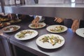 Team of chefs garnishing meal on counter Royalty Free Stock Photo