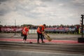 A team of cleaners in orange jackets cleans the racetrack on drag racing cars in Transnistria