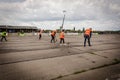 Team of cleaners in orange jackets cleans the racetrack on drag racing cars in Transnistria